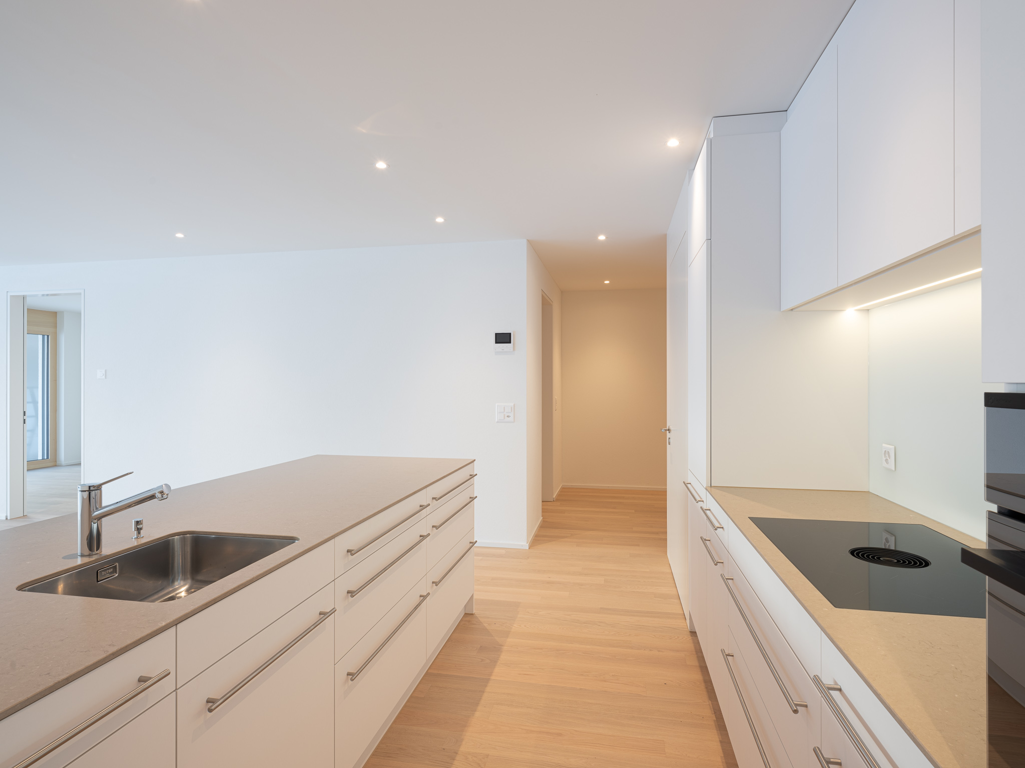 Offene Wohnküche mit Esszimmertisch und Sofa.