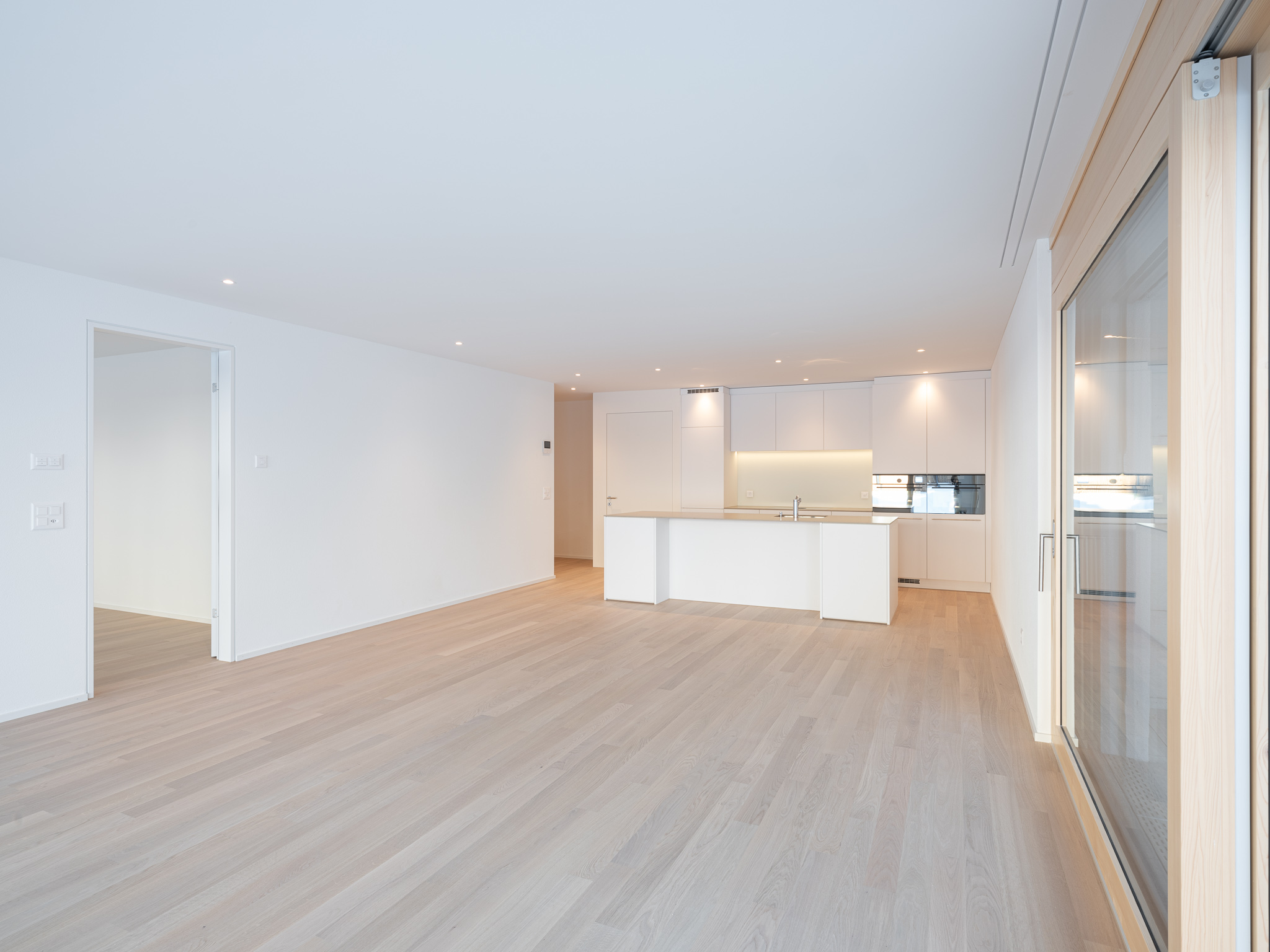 Wohnraum mit Esszimmertisch, Sofa und Terasse.