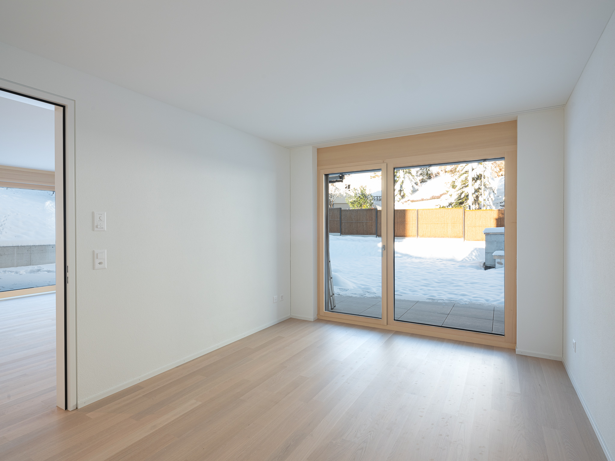 Offene Wohnküche mit Esszimmertisch und Sofa.