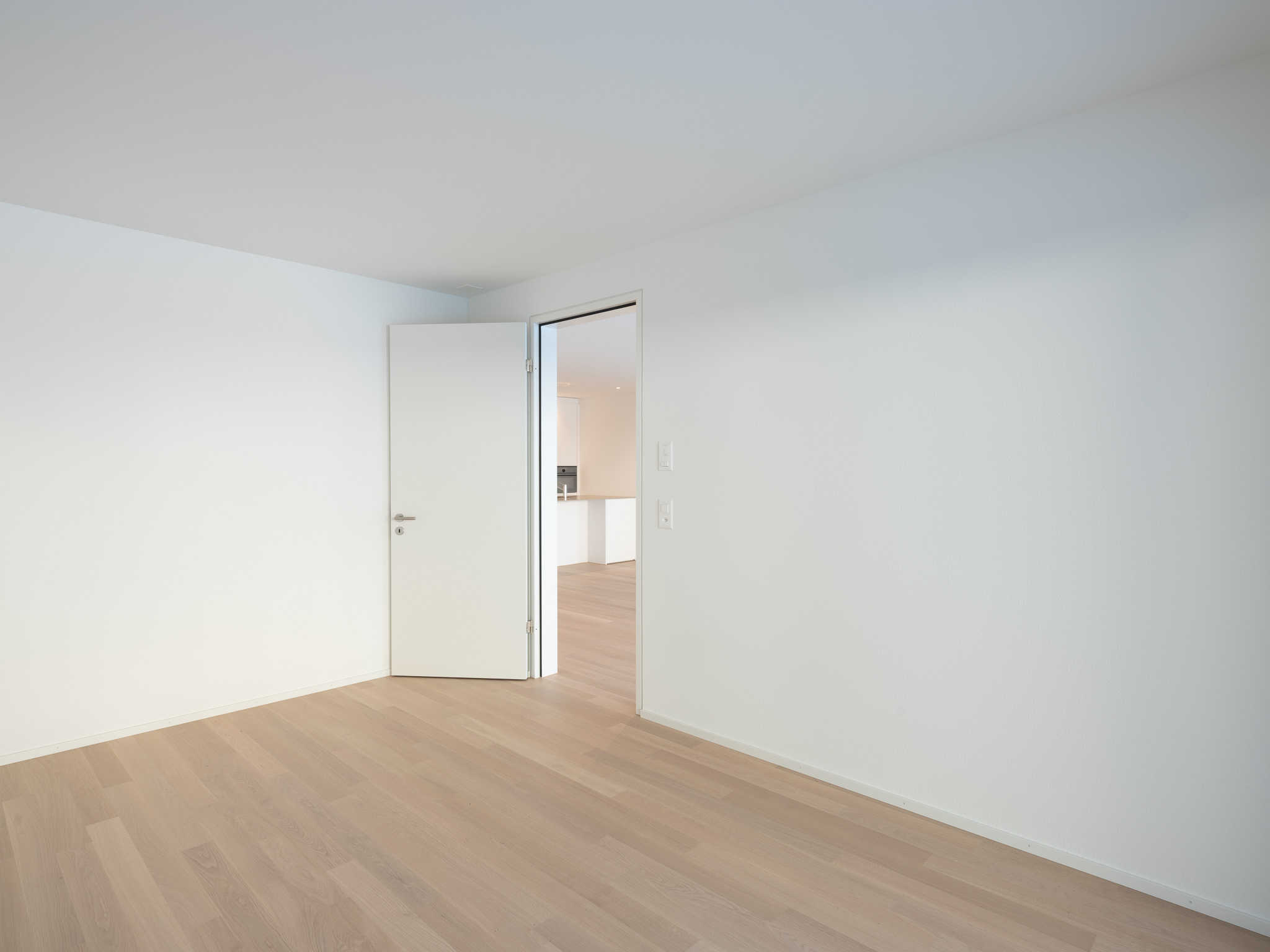 Offene Wohnküche mit Esszimmertisch und Sofa.