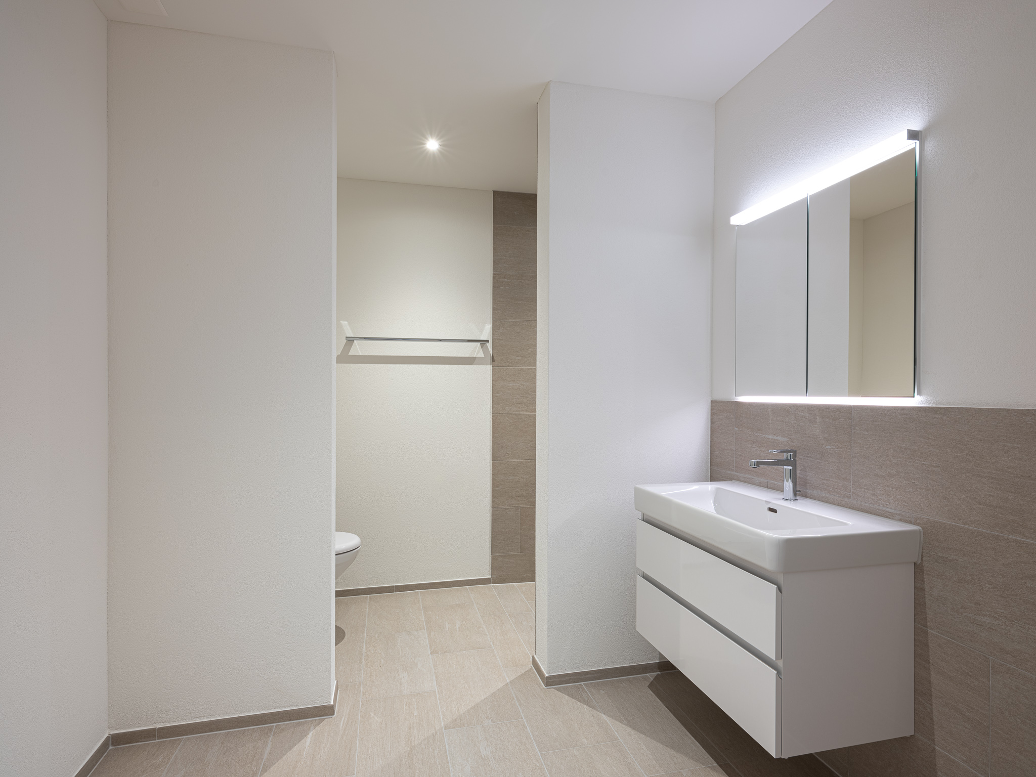 Offene Wohnküche mit Esszimmertisch und Sofa.